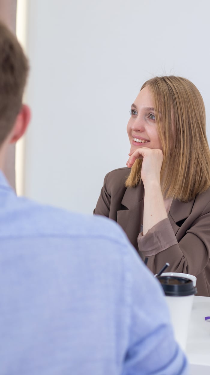 services-02 Smiling businesswoman engaged in a positive meeting with colleague.